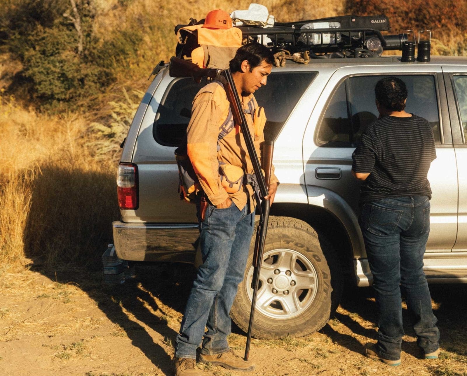 Two bird hunters get ready at a truck to go hunt quail in California.