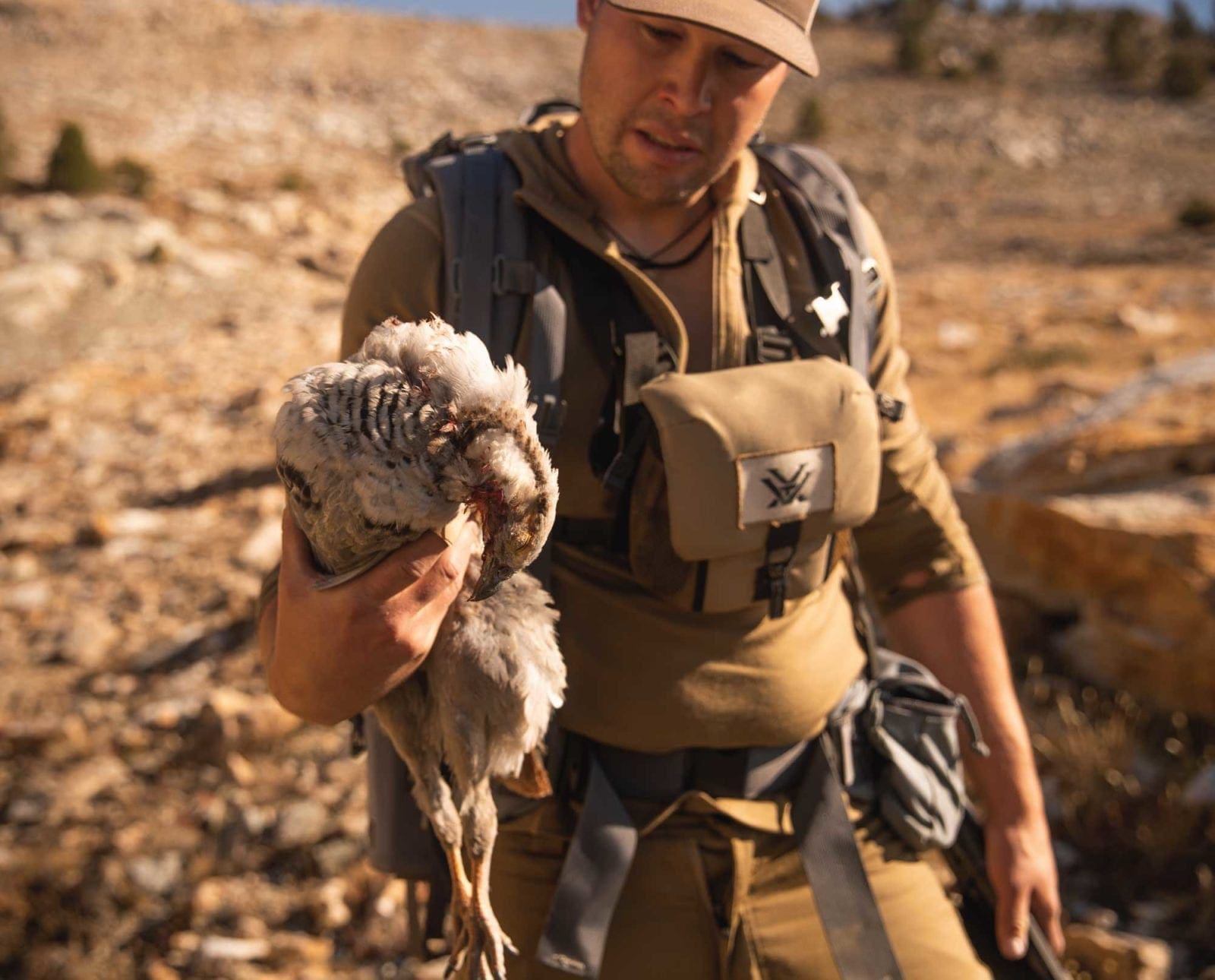A bird hunter with a Himalayan snowcock he just shot.