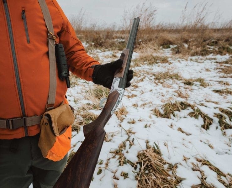 A pheasant hunter shows the shotgun he is using in the field.