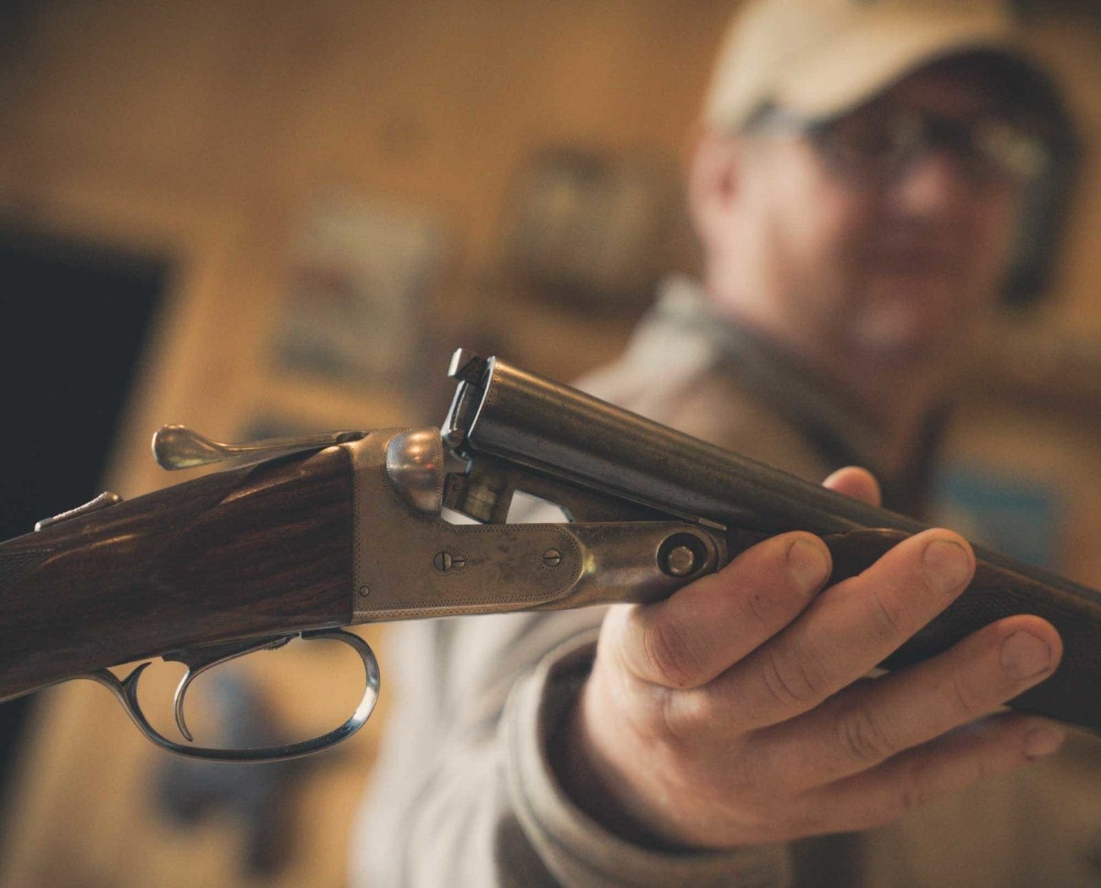 A man holding a 20 gauge AH Parker shotgun