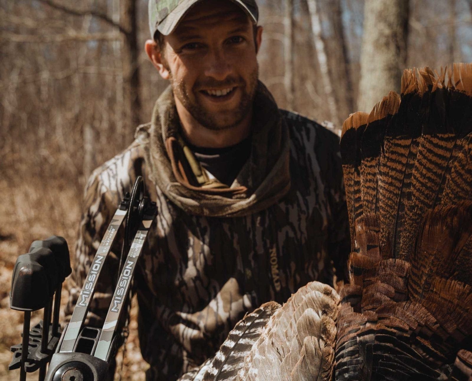 A bowhunter holds a wild turkey