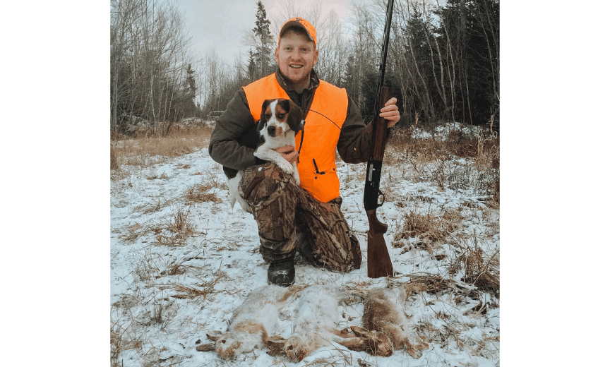 A hunter with a beagle and snowshoe hares