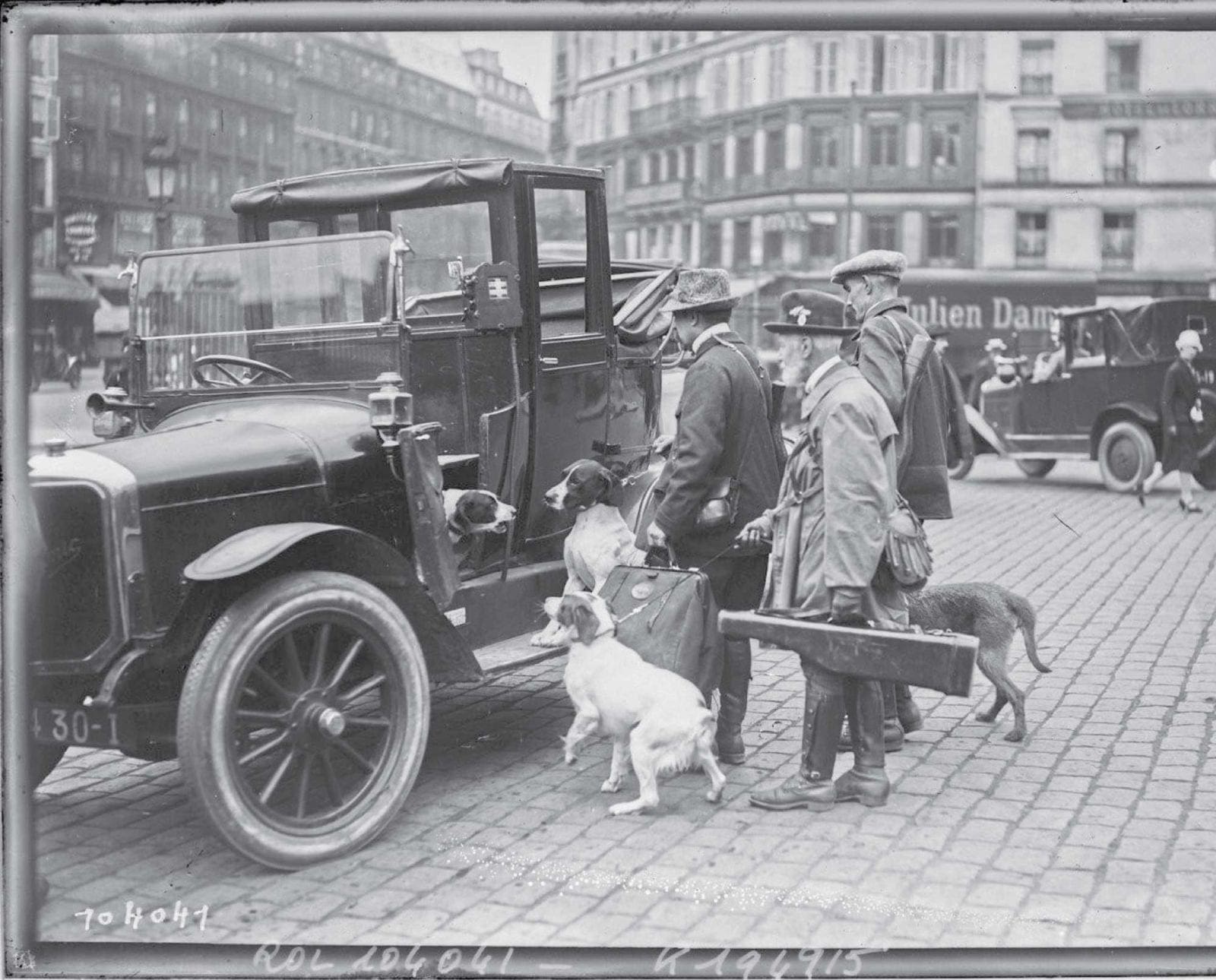 French hunters enter a taxi with hunting dogs and guns in 1925