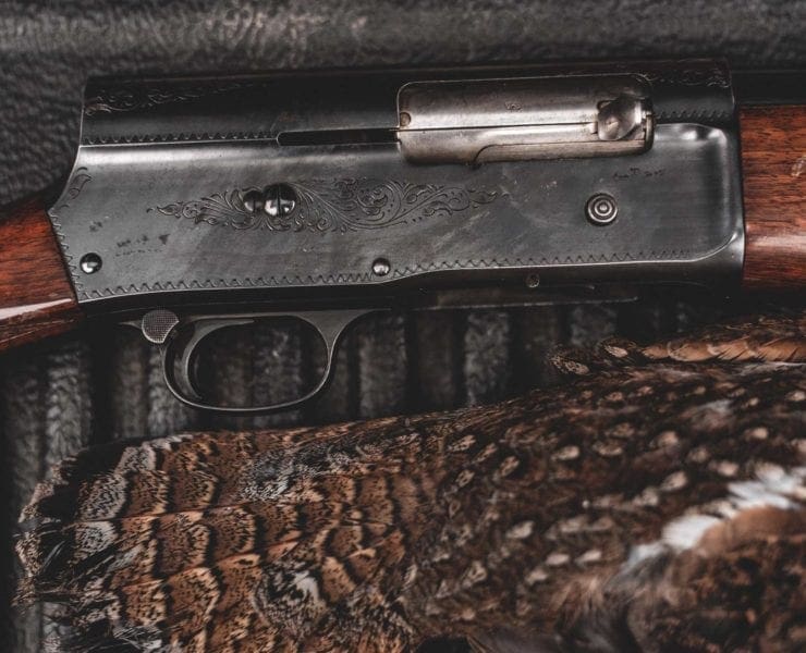 A browning A5 lays on the tailgate of a truck.