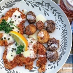 Pheasant schnitzel with beurre blanc sauce on a floral plate