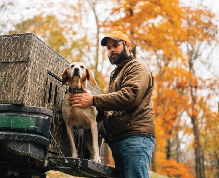 A racoon hunter with hos hound on a tailgate in Kentucky.