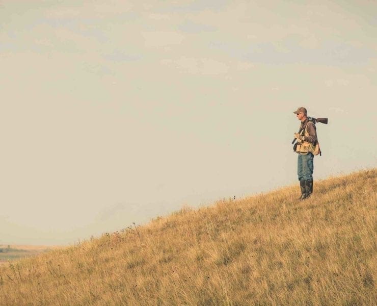 A bird hunter looks for prairie chickens in Kansas