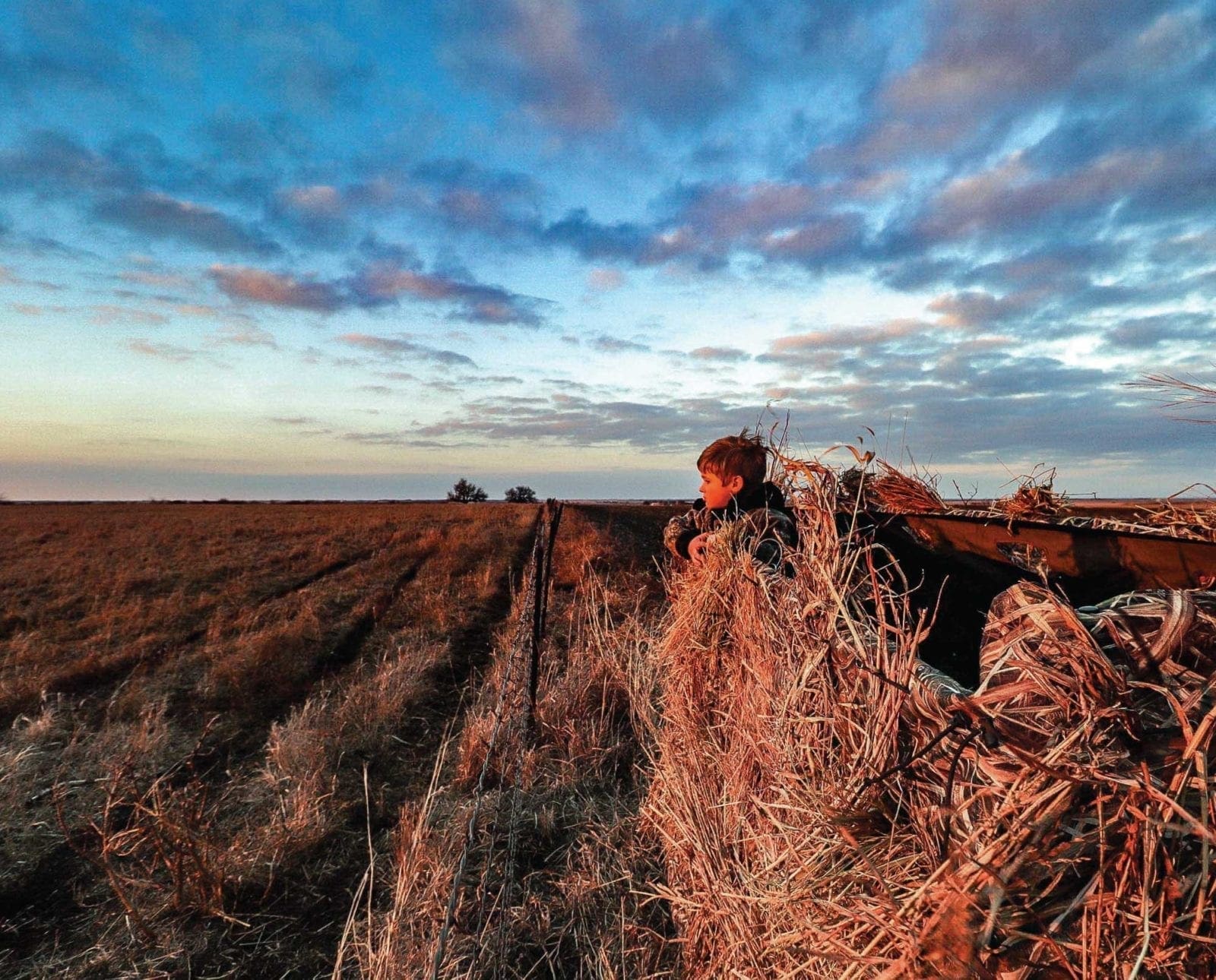 A young duck hunter stands in an A-frame blind