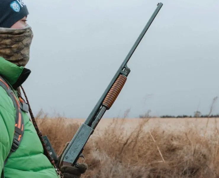 An Ithaca shotgun held by a bird hunter