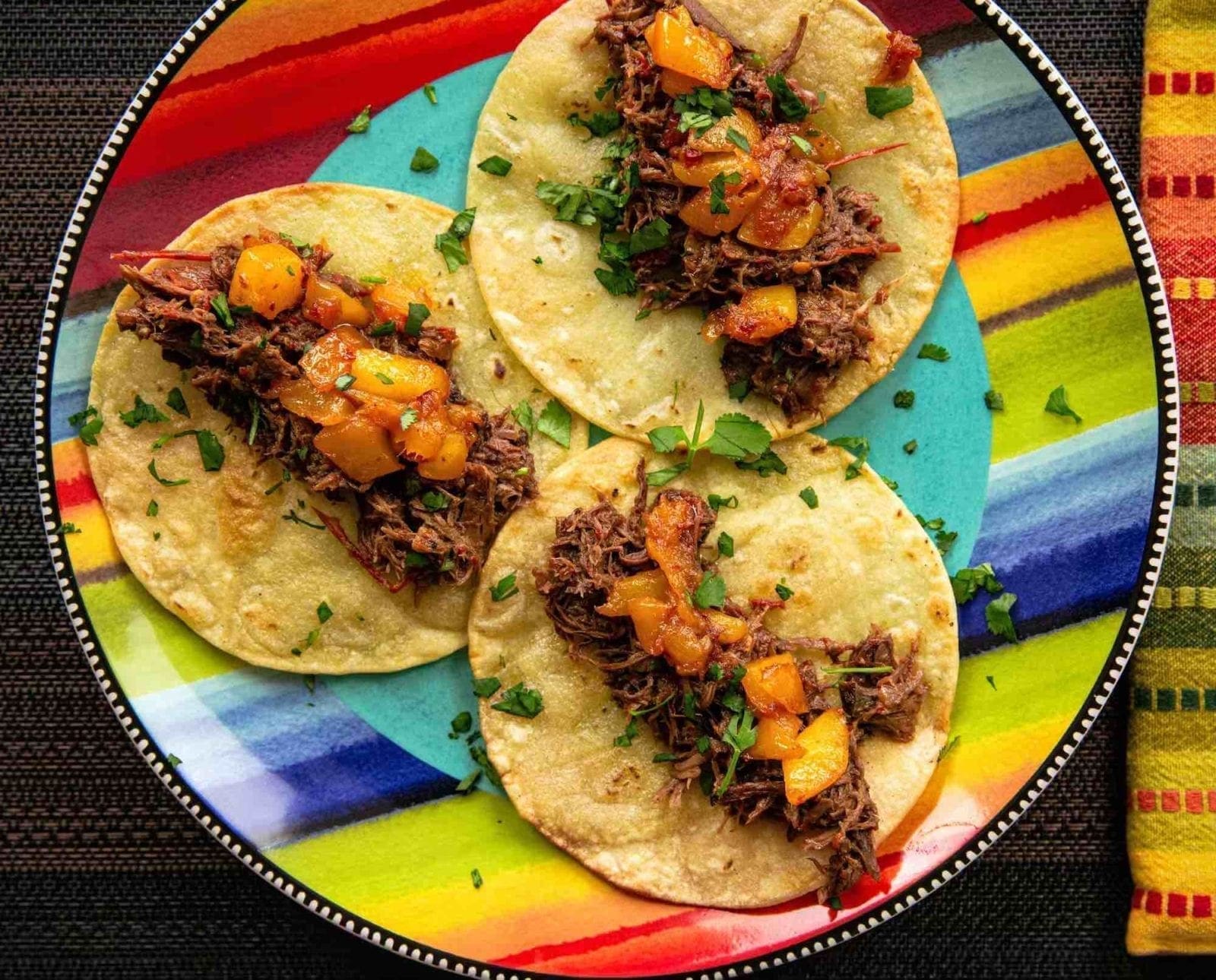 Three pulled-pheasant tacos on a colorful plate