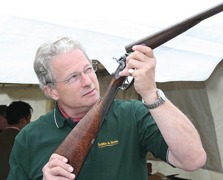 Guy Bignell of Griffin and Howe inspects a hammer shotgun.