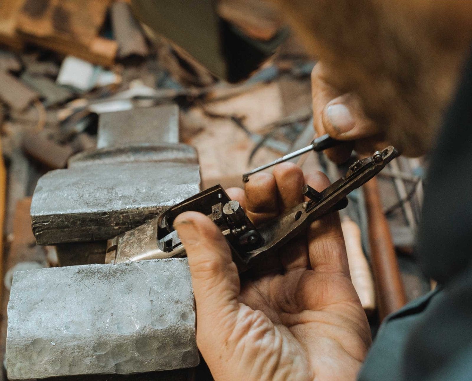 A gun smith works on a custom built shotgun.