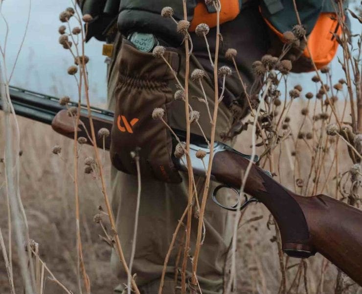 A bird hunter carries a Ruger Red Label shotgun in the field