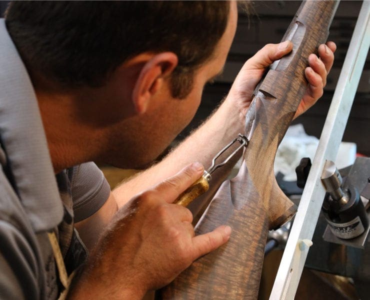 A Griffin and Howe gunsmith works on a rifle.
