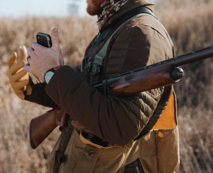 A hunter carries the iconic Remington 870 pump shotgun