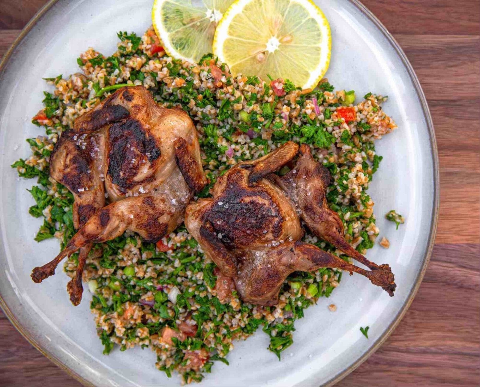 Grilled quail served atop a fresh tabbouleh salad