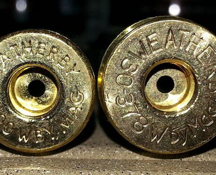 Two Weatheryby rifle rounds lie next to each other on a table.