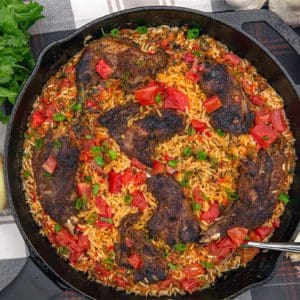 Arroz con prairie grouse rests in a cast iron skillet.