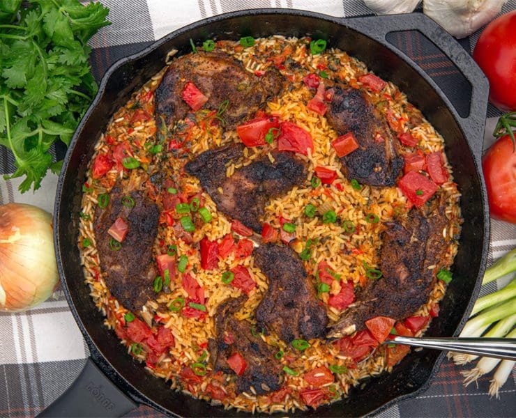 Arroz con prairie grouse rests in a cast iron skillet.