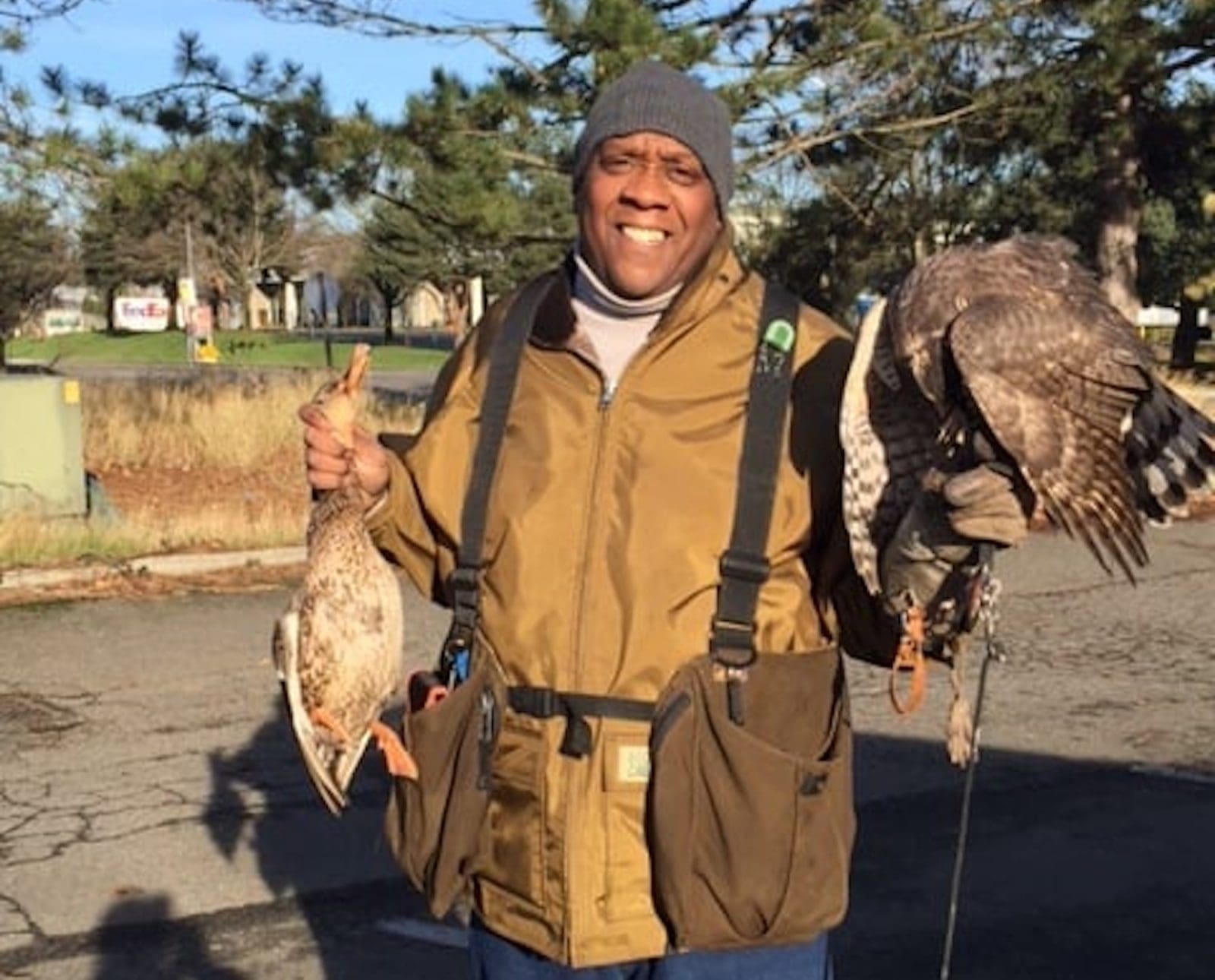 Falconer Anthony Williams holds his hawk and a duck