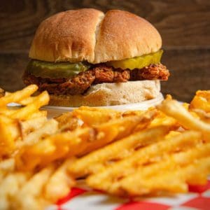 A chukar sandwich and fries rest on a table.