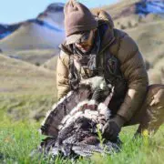 A hunter sits with a Rio Grande wild turkey he killed.