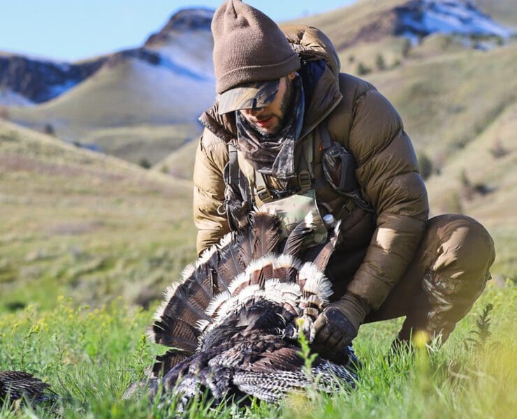 A hunter sits with a Rio Grande wild turkey he killed.
