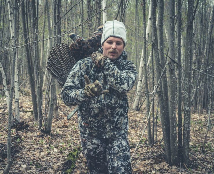A hunter carries out a turkey he killed.