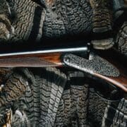 A grouse hunting shotgun with a group of ruffed grouse fans