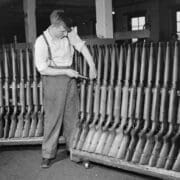 A worker shows a rack of new cooey rifles
