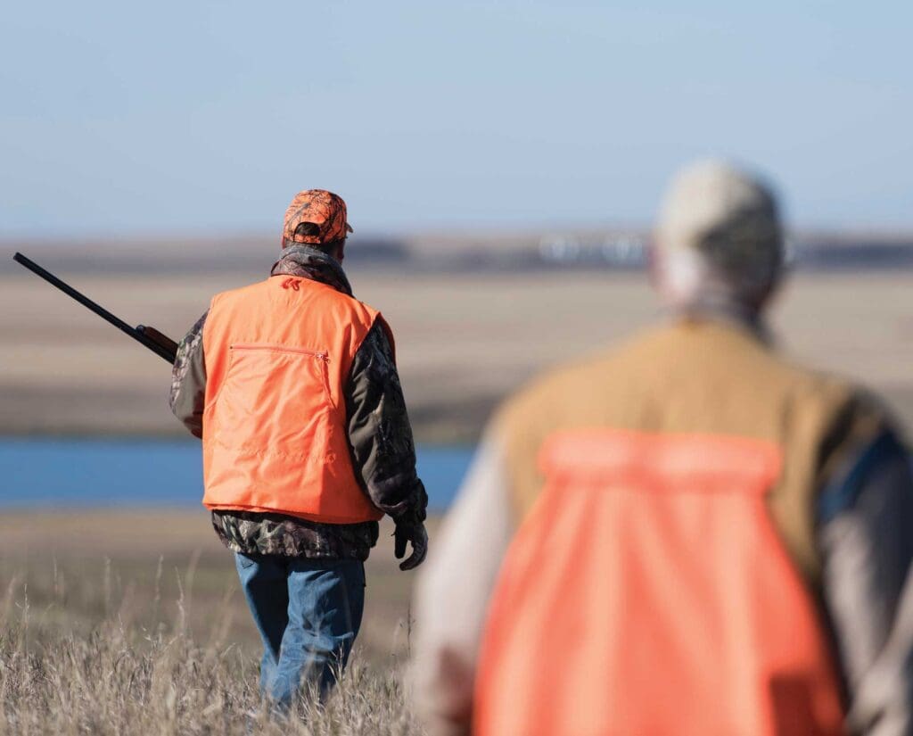 Bird hunters walk across a farm in Iowa while hunting
