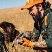 A sharptail grouse hunter with his bird dog