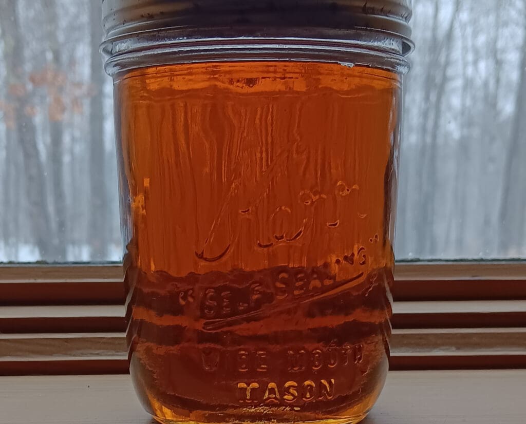 A mason jar of homemade maple syrup. 