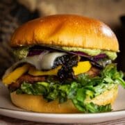 A fresh burger made from wild turkey meat and topped with mango, smokey mayo, cheese, and toasted greens
