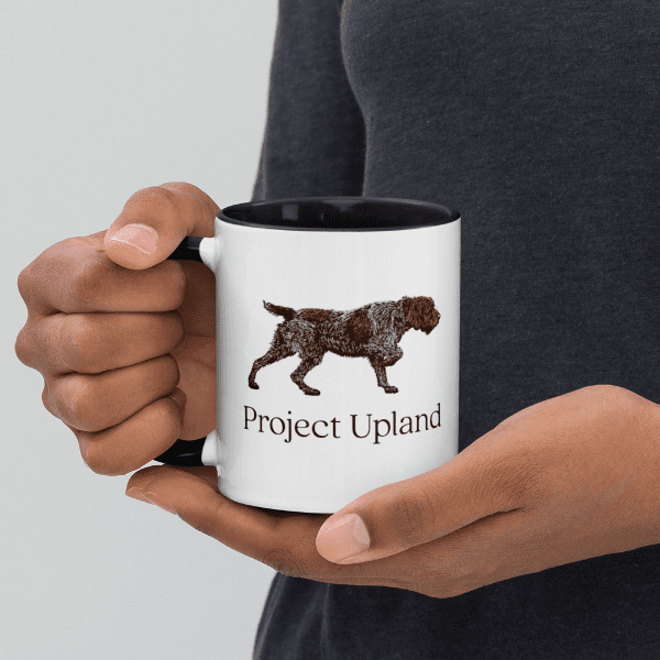 A man holding a wirehaired pointing griffon coffee mug.