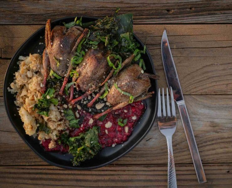 A plate of three whole-roasted doves with a champagne raspberry sauce, served with cauliflower