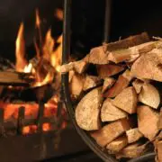 A bundle of split firewood with a fire burning in the background