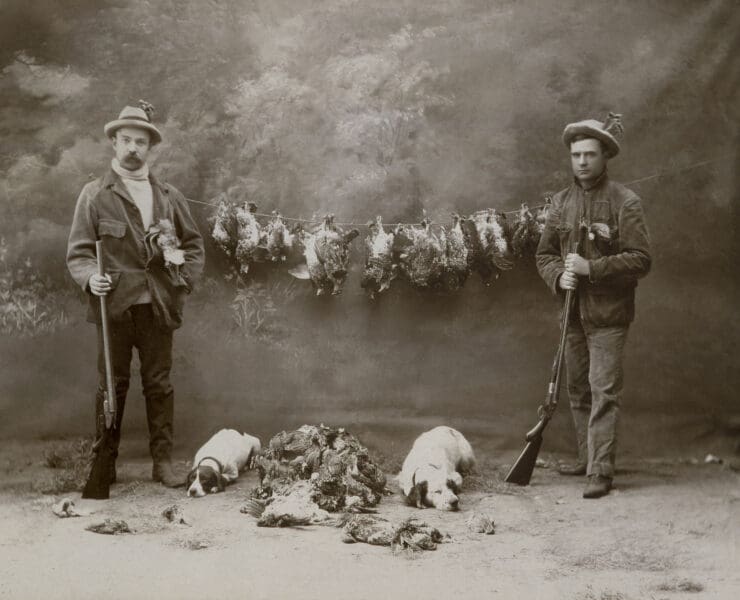 Two American hunters, one with a Pointer and the other with an English Setter.