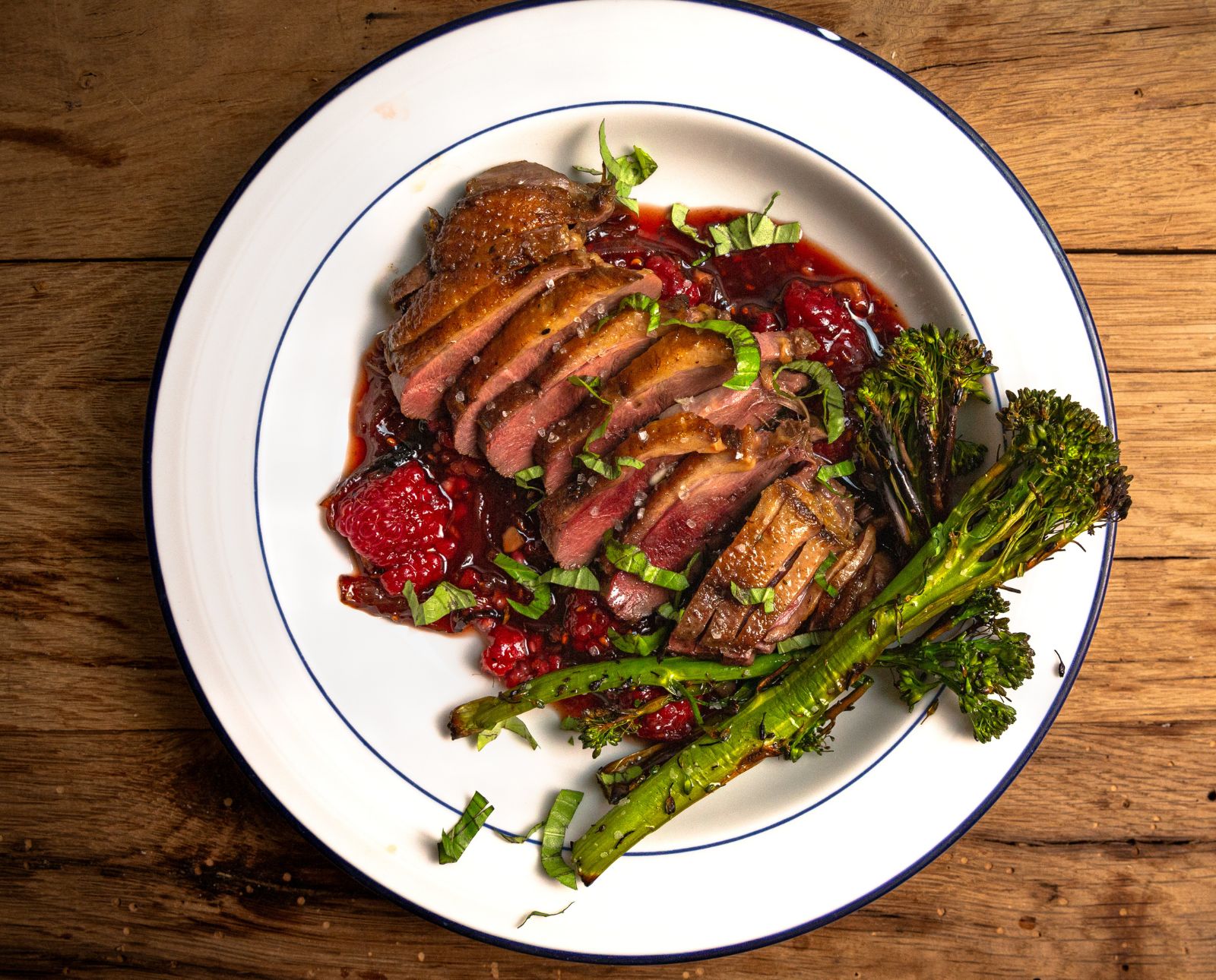 Sous vide duck breast with a spicy raspberry champagne sauce and broccolini.