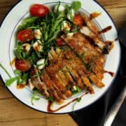 Crispy pan-fried pheasant breast served with an arugula and cherry tomato salad and a balsamic vinaigrette dressing.