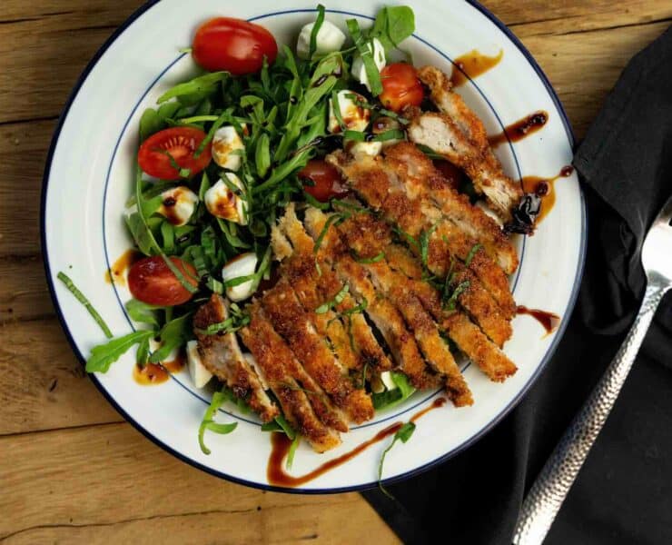 Crispy pan-fried pheasant breast served with an arugula and cherry tomato salad and a balsamic vinaigrette dressing.