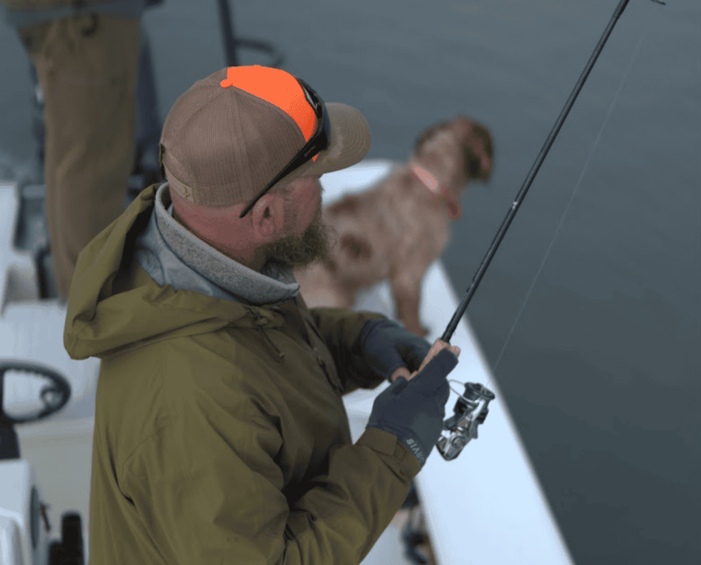 A bird hunter casts a fishing rod with his bird dog.