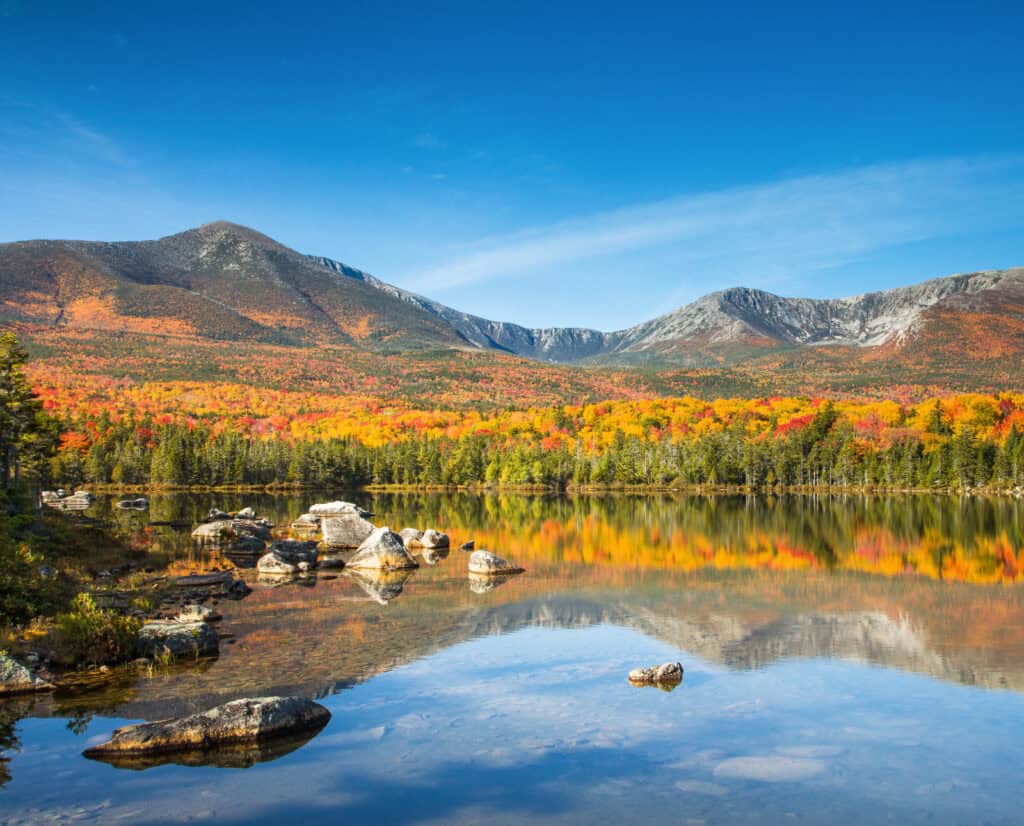 A lake surrounded by autumn leaves in Katahdin Woods and Waters National Monument.