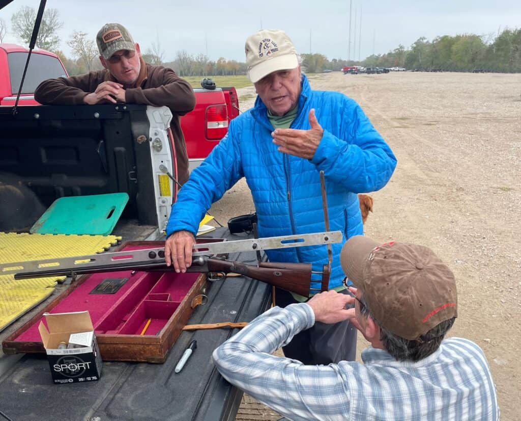 Jay Herbert and two clients near a truck tailgate examining a rare Churchill try gun.