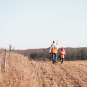 Two hunters walk through a harvested crop field in Ohio.