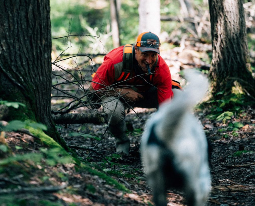 A dog trainer gets on a dogs level to maintain eye contact. 