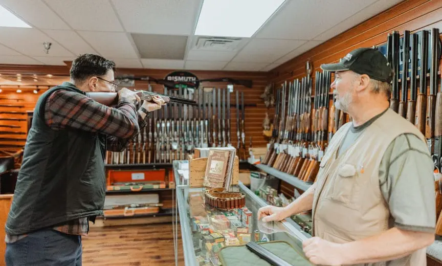 A bird hunter shoulders a used shotgun to see how it fits. 