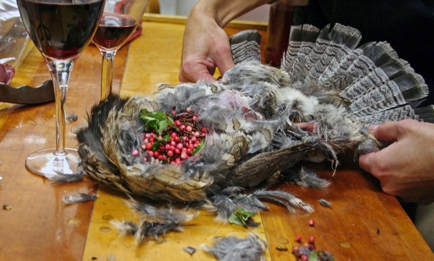 preparing a grouse dinner with wine at camp. 