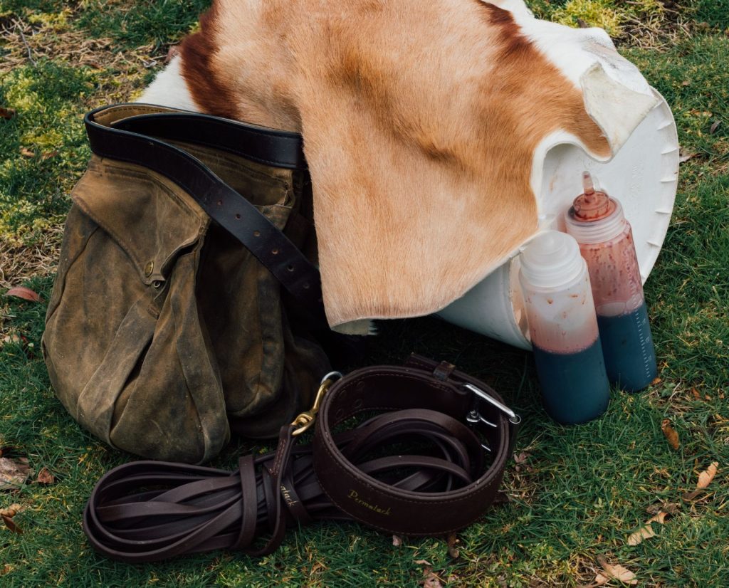 Equipment used to train a blood tracking dog, including a hide, blood, gear bags, and a specialized leash and collar.