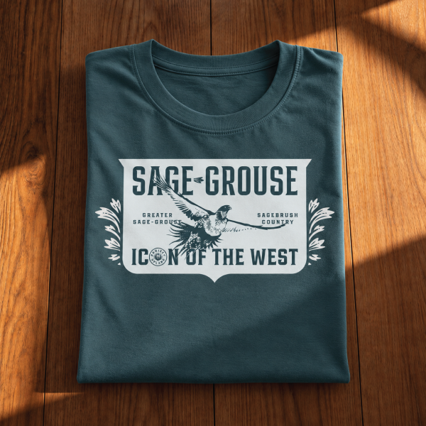Sage-Grouse-T-shirt-folded Sage grouse T-shirt folded on a wood surface.